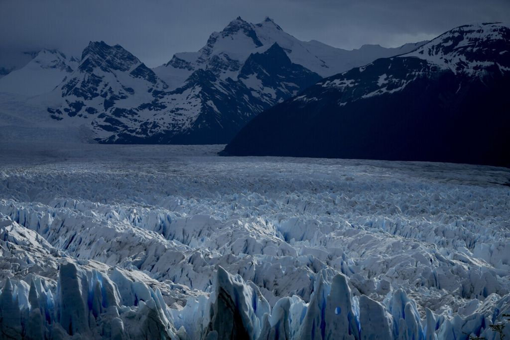 Hamparan es yang membentuk berbagai formasi pada glester Perito Moreno dengan latar belakang pegunungan di Taman Nasional Los Glaciares, Argentina, Senin (1/11/2021). Konferensi Tingkat Tinggi Perubahan Iklim dalam dua minggu ini akan membahas tentang isu pemanasan global. 