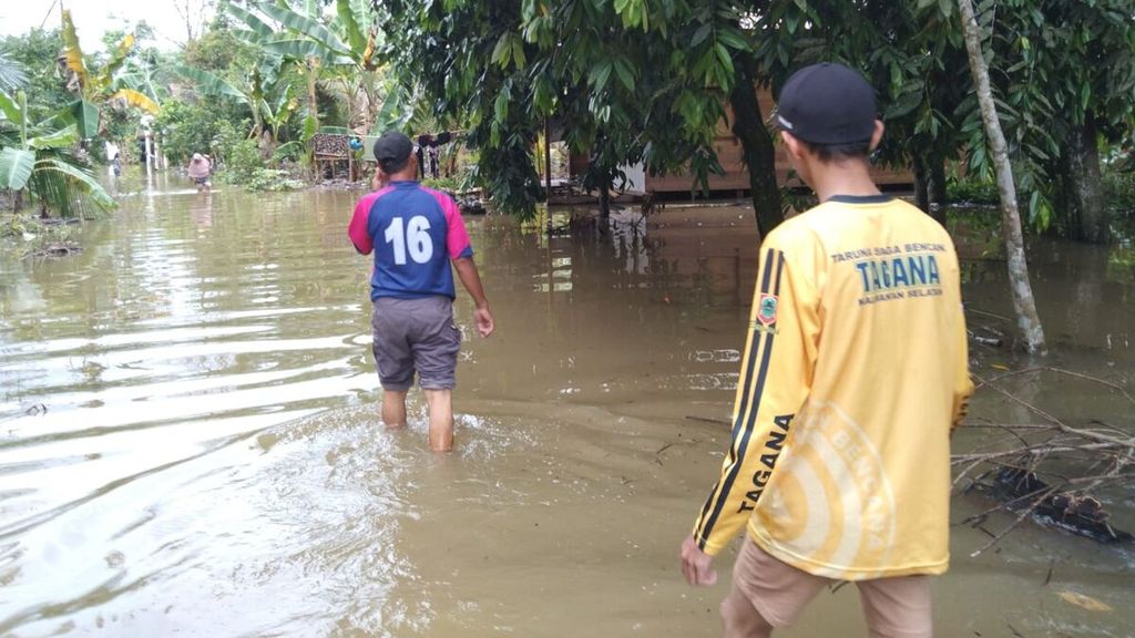 Warga berjalan melewati banjir di Desa Murung Padang, Kecamatan Banjang, Kabupaten Hulu Sungai Utara, Kalimantan Selatan, Rabu (17/1/2024).