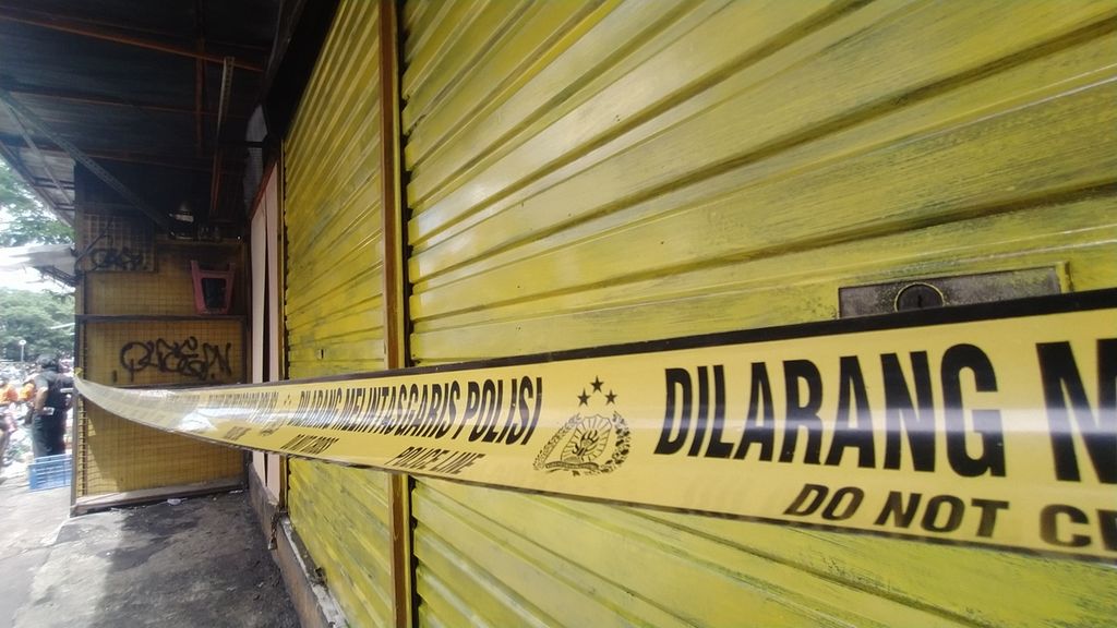 Garis polisi masih melintang di depan pintu tiga kios yang terbakar di kawasan Pasar Pagi Asemka, Kelurahan Pinangsia, Taman Sari, Jakarta Barat, Senin (21/11/2022).