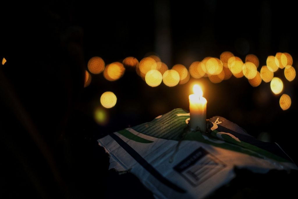 Seorang pengunjung menyalakan lilin dalam doa bersama di Kota Balikpapan, Kalimantan Timur, Senin (3/10/2022) malam. Ratusan pencinta sepak bola berkumpul dan berdoa bersama bagi ratusan korban akibat tragedi di Stadion Kanjuruhan, Malang, Jawa Timur.