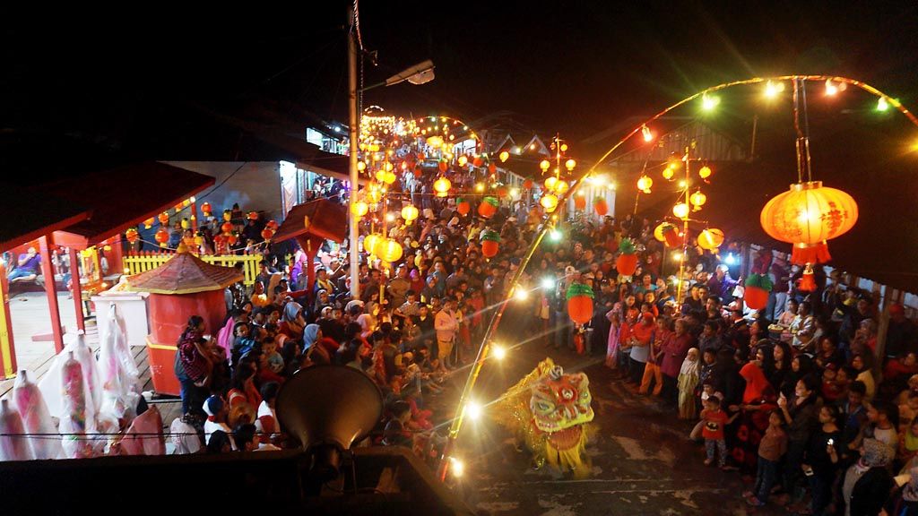 Residents of Ranai , Natuna, gather at the Fuk De Chi Temple, Penagih, Natuna, Riau Islands, on Friday (28/1/2017) evening to watch the barongsai (dragon dance) held to commemorate Imlek, the Chinese New Year. Malay and Chinese residents have built and realized togetherness in their daily lives. The picture was taken from the top of the small Al Muqarramah Mosque, which is located next to the temple.