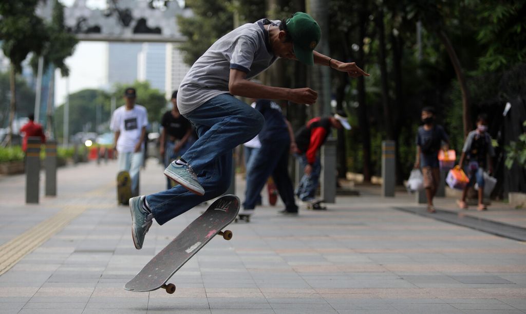 Warga bermain <i>skateboard</i> di trotoar Jalan Jenderal Sudirman-Thamrin, Jakarta, Jumat (12/3/2021). Gubernur DKI Jakarta Anies Baswedan mengizinkan trotoar untuk digunakan sebagai lahan bermain <i>skateboard</i> dengan beberapa kesepakatan. Para pemain <i>skateboard</i> diimbau  tetap mematuhi norma di masyarakat dan tidak mengganggu ketertiban umum. 