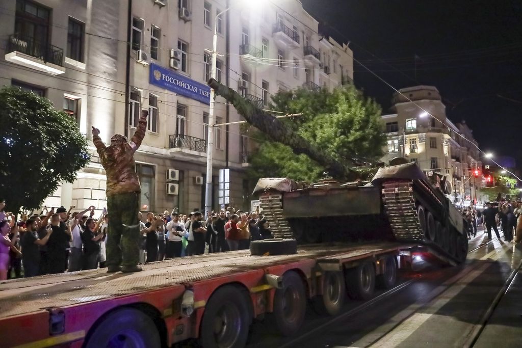 Anggota militer kelompok Wagner memuat tank mereka ke sebuah truk di jalan Rostov-on-Don, Rusia, Sabtu (2/6/2023) 