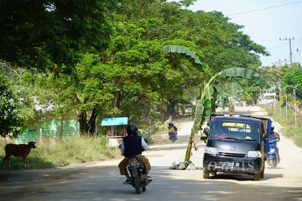 Pengendara zig-zag saat melintasi jalan provinsi yang rusak dan ditanami pisang di Desa Watumerembe, Palangga, Konawe Selatan, Sulawesi Tenggara, awal April 2021. <i>Zig-zag</i> memiliki padanan <i>siku-saki</i>.