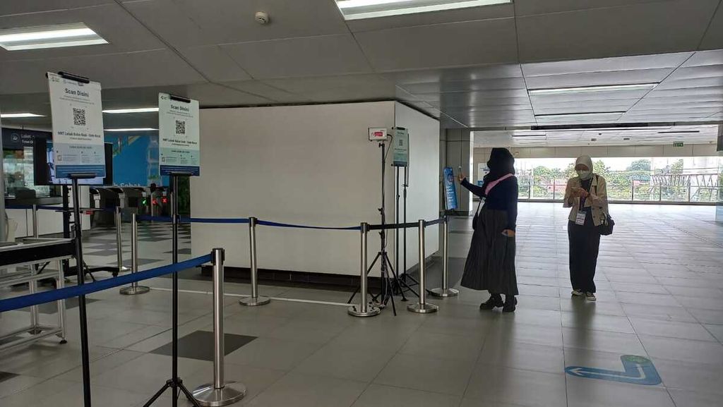 Penumpang MRT Jakarta di Stasiun Lebak Bulus, Sabtu (19/11/2022), memindai <i>barcode </i>aplikasi Peduli Lindungi sebelum memasuki stasiun.