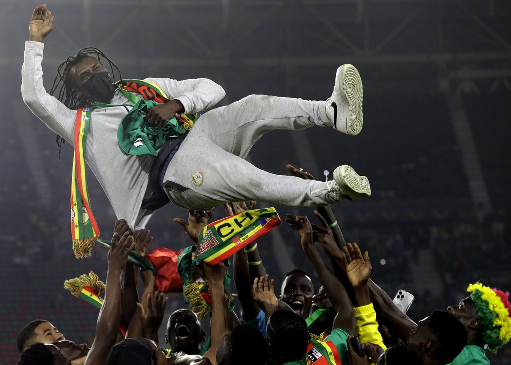 Para pemain Senegal merayakan gelar juara Piala Afrika 2021 dengan mengangkat pelatihnya, Aliou Cisse, seusai final versus Mesir di stadion Ahmadou Ahidjo di Yaounde, Kamerun, Minggu (6/2/2022). 