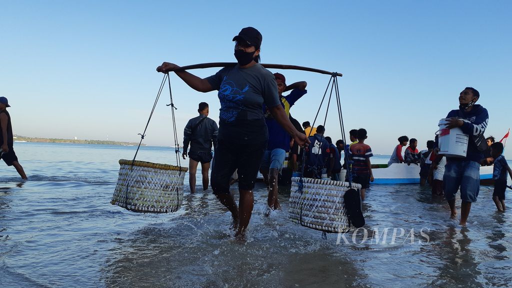 Perempuan pedagang ikan baru saja membeli ikan dari nelayan di Pantai Oesapa, Kota Kupang, NTT, Rabu (18/8/2021).  