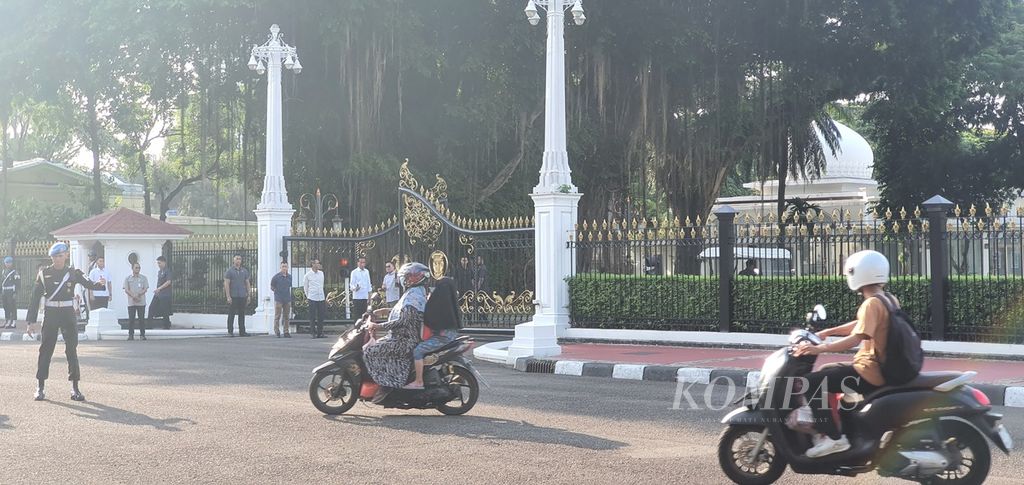 Presiden Joko Widodo memantau pembagian paket bahan pangan dari pagar Istana Merdeka, Jakarta, Senin (8/4/2024). Warga yang menerima pun meneriakkan ucapan terima kasih dan dibalas lambaian Presiden.