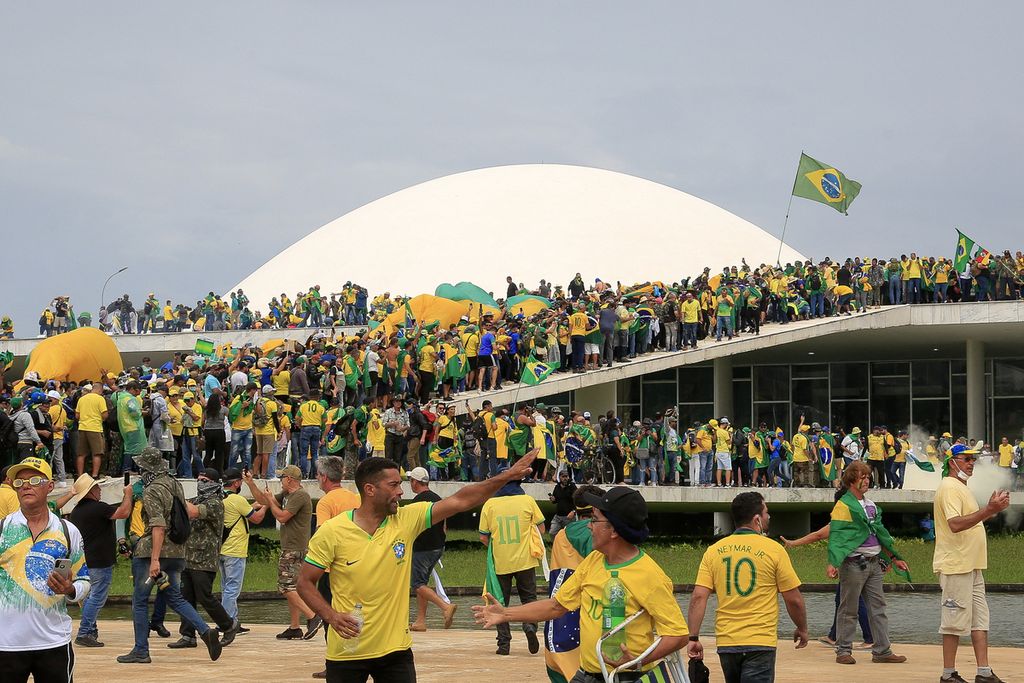 Pendukung mantan Presiden Brasil Jair Bolsonaro menyerbu Kongres Nasional di Brasilia, Minggu (8/1/2023). Ribuan orang menerobos barikade polisi dan menyerbu kongres, istana kepresidenan, dan mahkamah agung untuk memprotes pelantikan Presiden Luiz Inacio Lula da Silva pekan lalu.