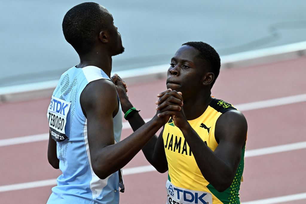  Pelari Botswana, Letsile Tebogo (kiri), dan pelari Jamaika, Oblique Seville, bergandengan tangan usai bertanding dalam semifinal lari 100 meter putra pada Kejuaraan Dunia Atletik 2023 di Budapest, Hongaria, Sabtu (19/8/2023). 