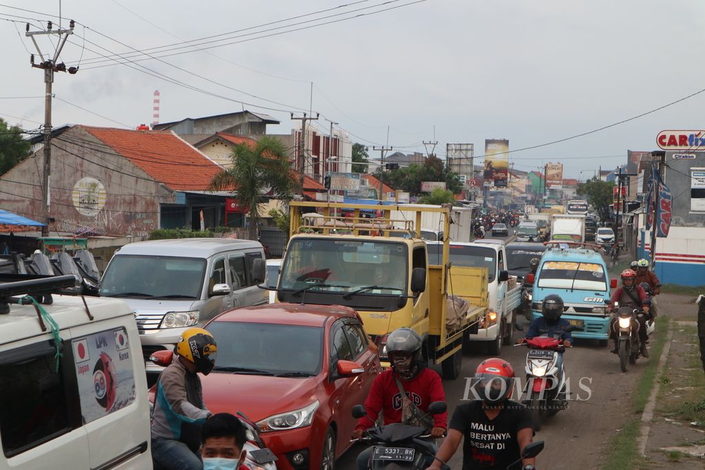 Kendaraan yang mengarah ke Jakarta mengantre di Mundu, Kabupaten Cirebon, Jawa Barat, Jumat (29/4/2022) sore. Imbas penerapan sistem satu arah (<i>one way</i>) di jalan tol menuju Jawa, jalur pantura Cirebon arah ke Jakarta mengalami kepadatan.