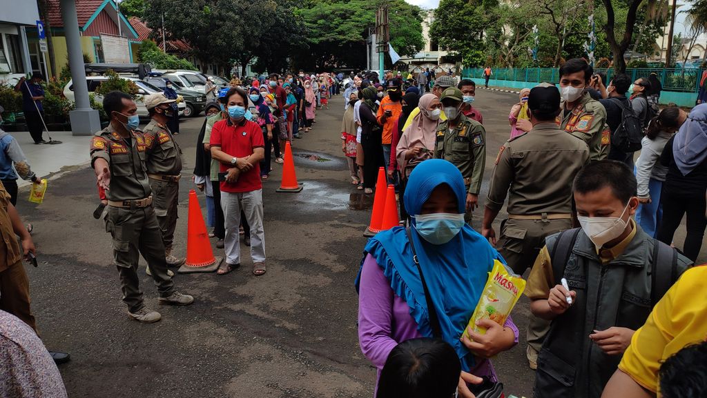 Ratusan orang antre membeli minyak goreng saat operasi pasar minyak goreng di Kantor Kecamatan Pamulang, Tangerang Selatan, Banten, Selasa (11/1/2022). Sebanyak 4.000 liter minyak goreng yang dijual Rp 14.000 per liter disiapkan dalam operasi pasar ini.