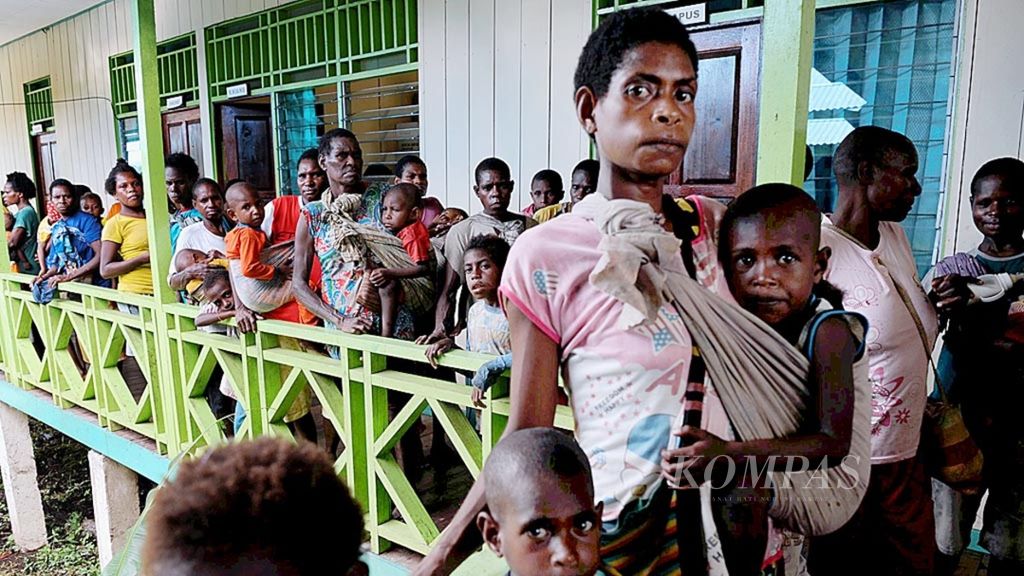 Warga antre mendapatkan layanan kesehatan di Puskemas Ayam, Distrik Akat, Kabupaten Asmat, Papua, Jumat (26/1/2018). 