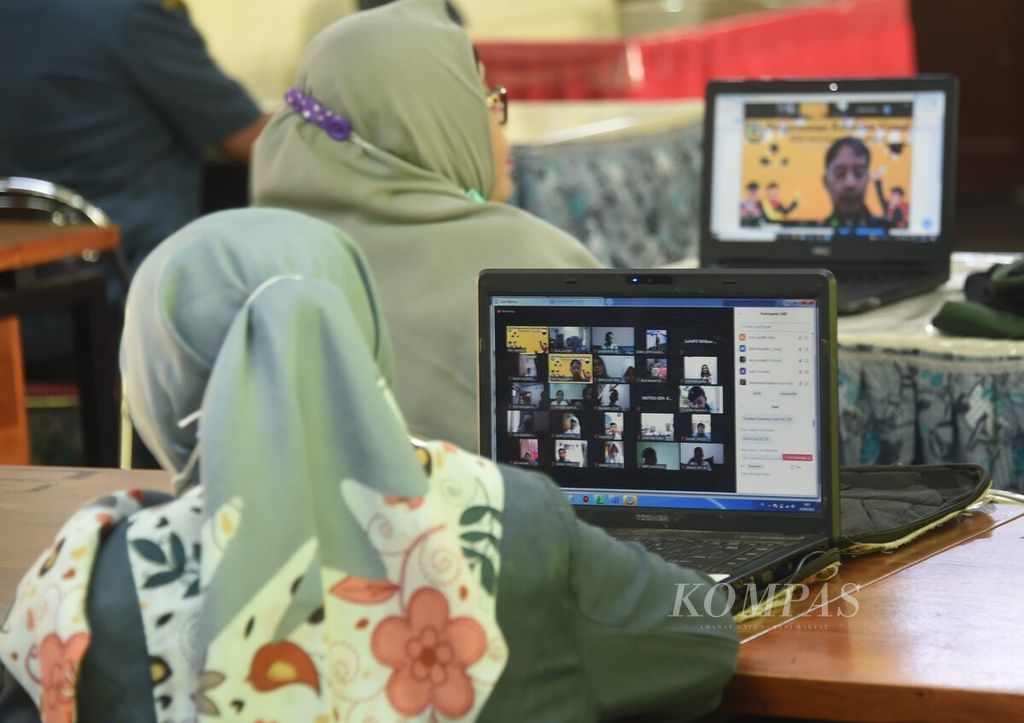 Guru mengamati berlangsungnya kegiatan pengumuman kelulusan secara daring di SD Negeri 1 Kaliasin, Surabaya, Jawa Timur, Selasa (15/6/2021). 