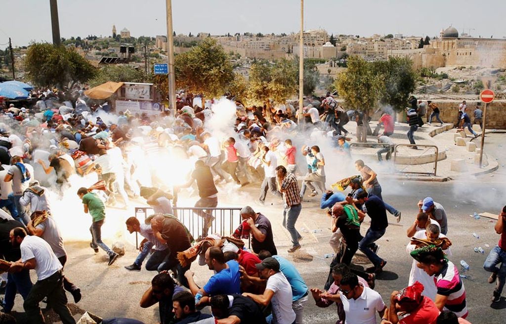 Warga Palestina berlarian saat pasukan keamanan Israel melepaskan gas air mata untuk membubarkan massa yang berkumpul setelah shalat Jumat di luar Kota Tua Jerusalem, Jumat (21/7). 