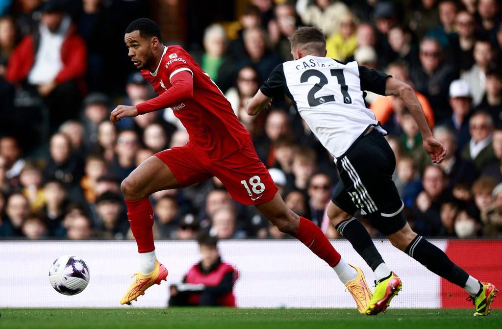 Fulham defender Timothy Castagne (right) and Liverpool winger Cody Gakpo compete for the ball during the English Premier League match between Fulham and Liverpool at Craven Cottage Stadium in London, early morning of Monday (22/4/2024) WIB.