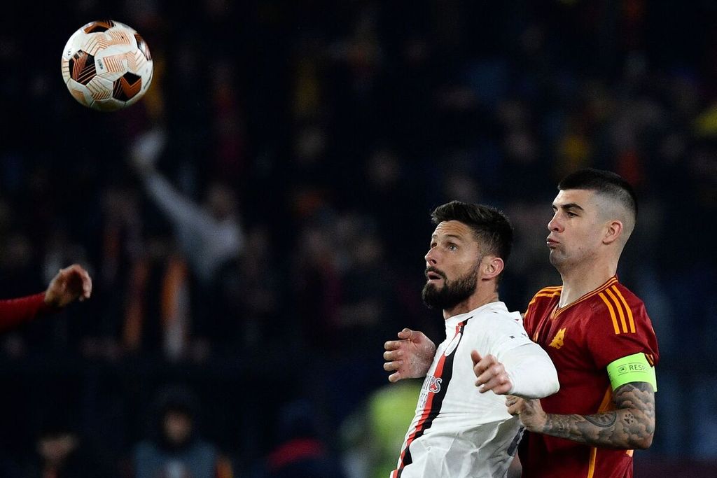 AC Milan striker Olivier Giroud and AS Roma defender Gianluca Mancini compete for the ball during the second quarter-final match of the Europa League between AS Roma and AC Milan at the Olimpico Stadium in Rome on Friday (19/4/2024) early morning WIB.
