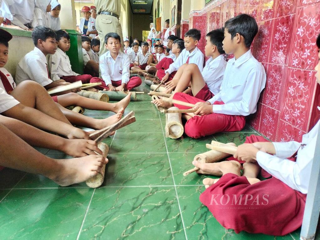 Dengan kentongan masing-masing, siswa-siswa SD Ringinputih II, Kecamatan Borobudur, Kabupaten Magelang, Jawa Tengah, bersiap latihan musik untuk <i>cheering</i> Borobudur Marathon 2022, Senin (7/11/2022).