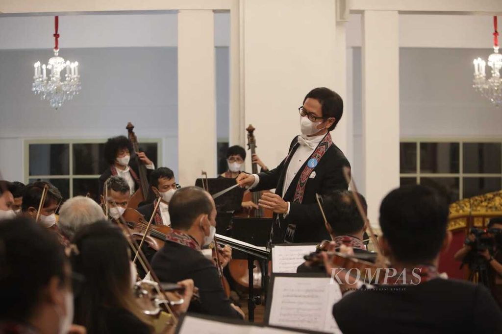 Addie MS memimpin Twilite Orchestra yang tampil dalam acara Kompas100 CEO Forum yang berlangsung di Istana Negara, Jakarta, Jumat (2/2/2022). 
