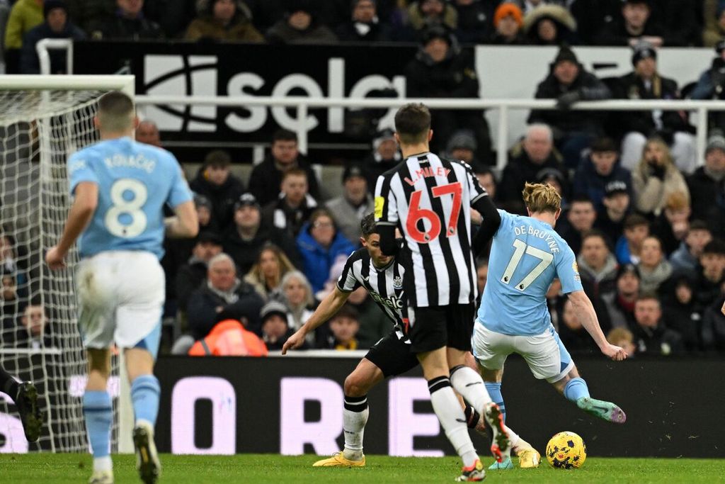 Gelandang Manchester City, Kevin De Bruyne (kanan), menembak bola yang berujung gol timnya ke gawang Newcastle United, 13 Januari 2024. 