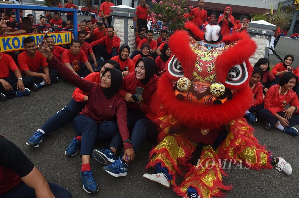Lion dancers with members of the Indonesian Navy following a group exercise at the Ujung Koarmada II Pier in Surabaya, East Java, on Tuesday (31/1/2023).