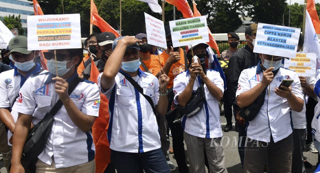 Para buruh kembali berunjuk rasa di depan Gedung DPR, Senayan, Jakarta, Senin (7/2/2022). Massa buruh dari Federasi Serikat Pekerja Metal Indonesia (FSPMI) dan elemen lainnya tetap mengajukan tuntutan menolak UU Cipta Kerja dan meminta revisi UMP/UMK di wilayah selain DKI Jakarta.  