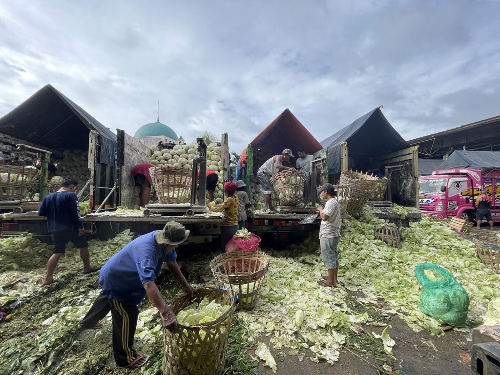 Suasana setelah truk pengangkut kubis tiba di Pasar Kramatjati, Jakarta Timur, Jumat (17/2/2023). Sebelum diangkut ke lapak, kubis akan dikupas dan ditimbang lebih dahulu. Adapun kupasan sayur yang dikenal dengan sebutan kol itu dikumpulkan oleh para pemulung.