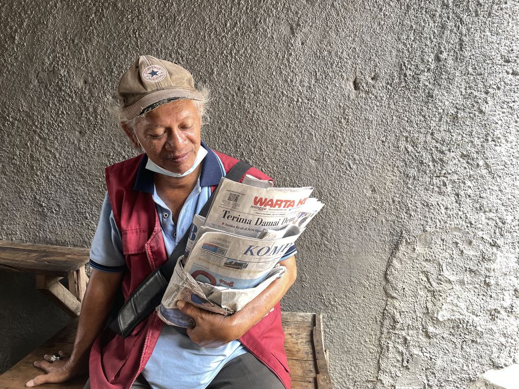 Rahmad (53) berjualan koran dengan berkeliling Pasar Jatinegara, Jakarta Timur, Minggu (10/10/2021). 
