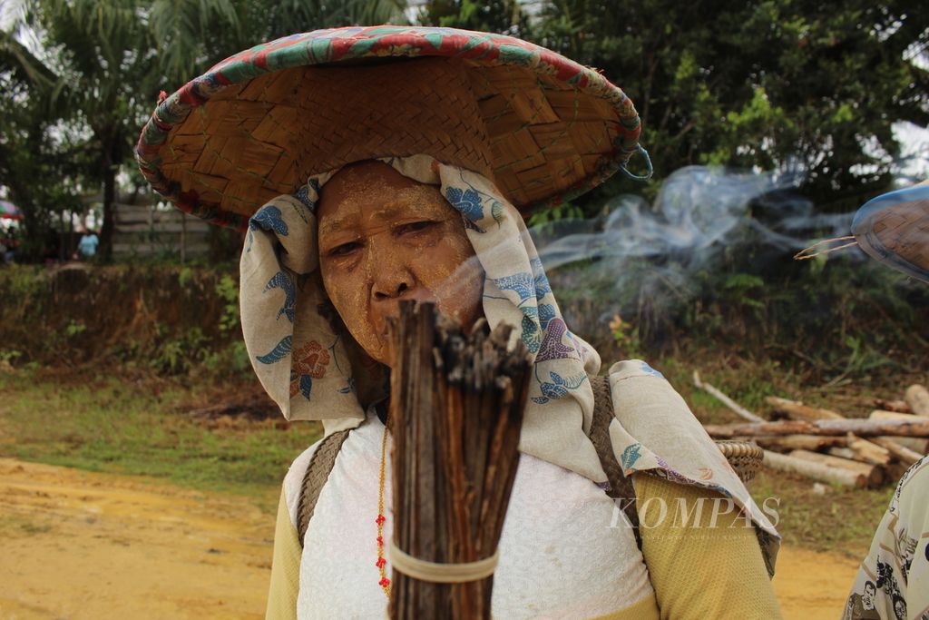 Peladang asal Desa Tumbang Oroi menunjukkan <i>sambutut</i>, kulit kelapa yang diikat lalu dibakar, di sela-sela peringatan Hari Tani Nasional di Gunung Mas, Kalimantan Tengah, pada Sabtu (25/9/2022). <i>Sambutut</i> biasa dibawa untuk menyalakan api karena bisa tahan lama. Api itu digunakan untuk membersihkan lahan hingga memasak di pondok,