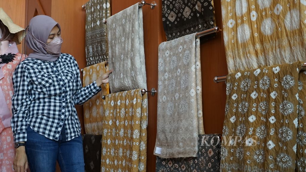 Seorang pengunjung melihat kain jumputan Rumah Pewarna Alami yang terletak di Kawasan Kebun Raya Sriwijaya, Kecamatan Indralaya Utara, Kabupaten Ogan Ilir, Sumatera Selatan, Selasa (8/3/2022). Ini merupakan salah satu inovasi yang dilakukan agar jumputan lebih ramah lingkungan.