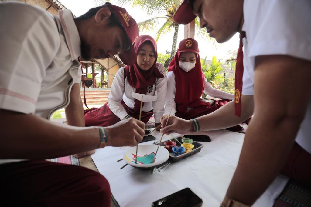 Sejumlah peserta Borobudur Creative Race melukis di atas gerabah produksi warga Desa Karanganyar, Kecamatan Borobudur, Kabupaten Magelang, Jawa Tengah, Sabtu (17/9/2022). Selain berlomba, dalam ajang ini, warga bisa sekaligus mengenal dan mengetahui potensi yang ada di sekitar kawasan Candi Borobudur.