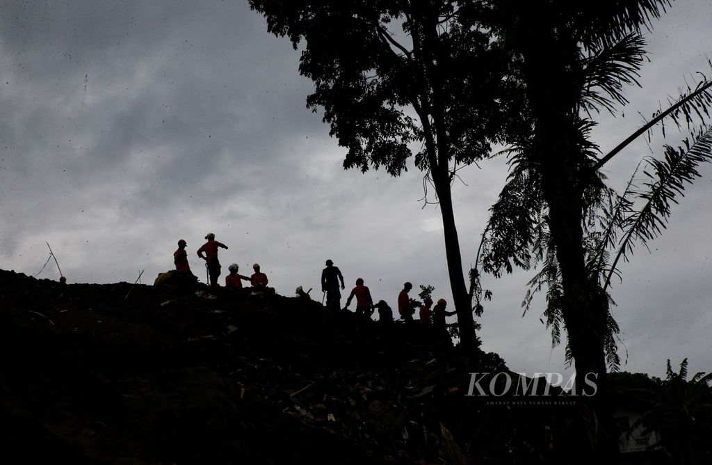 Siluet personel Tim SAR Gabungan yang melakukan pencarian korban tanah longsor yang disebabkan gempa bumi bermagnitudo 5,6 di Desa Cijedil, Kecamatan Cugenang, Kabupaten Cianjur, Jawa Barat, Sabtu (26/11/2022).