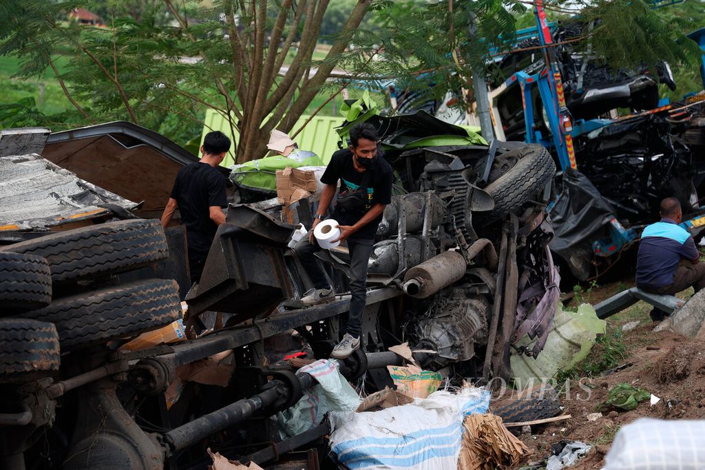 Pekerja mengeluarkan muatan salah satu truk yang mengalami tabrakan beruntun di jalan Tol Semarang-Surakarta, Kabupaten Boyolali, Jawa Tengah, Jumat (14/4/2023). 