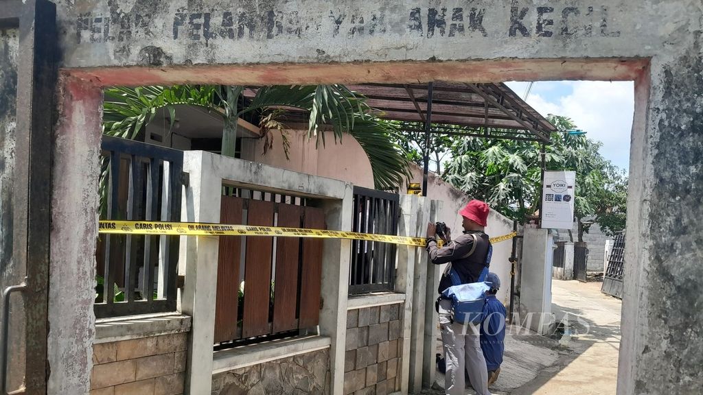 Dua jurnalis mengabadikan proses identifikasi oleh polisi di rumah sewa korban bunuh diri keluarga di Dusun Borobugis, Desa Saptorenggo, Kecamatan Pakis, Kabupaten Malang, Jawa Timur, Selasa (12/12/2023).