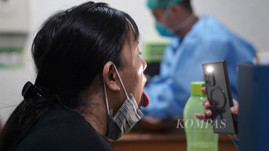 Dokter memeriksa pasien dengan gejala batuk di poli batuk dan infeksi saluran pernapasan akut (ISPA) di Puskesmas Kecamatan Cilincing, Jakarta Utara, Selasa (22/8/2023).