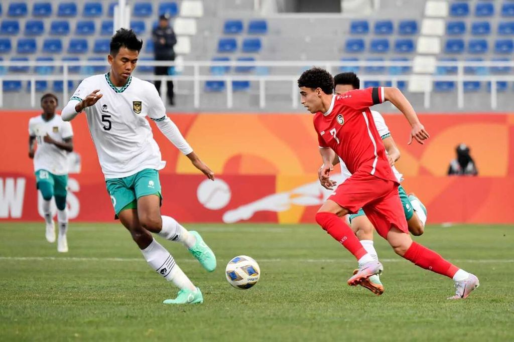 Bek Indonesia, Kakang Rudianto (kiri), mengawal pemain Suriah pada laga penyisihan Grup A di Tashkent, Uzbekistan, Sabtu (4/3/2023) malam WIB. Indonesia menang, 1-0.