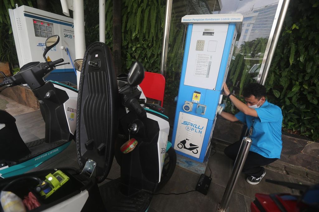  Petugas mengisi daya motor listrik di stasiun pengisian kendaraan listrik umum (SPKLU) di halaman Kantor PLN Distribusi Jakarta Raya, Jakarta, Senin (22/11/2021). Saat ini PLN telah memiliki 47 unit SPKLU yang beroperasi dan hingga akhir tahun akan ada 67 SPKLU yang beroperasi. Infrastruktur itu diperlukan untuk mendukung percepatan pengembangan kendaraan bermotor listrik berbasis baterai.