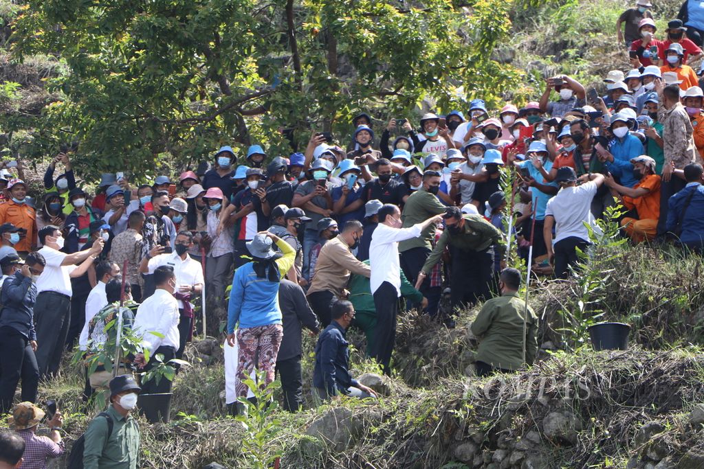 Presiden Joko Widodo menanam pohon bersama ratusan warga di bukit terjal di tepi Danau Toba, Desa Simangulampe, Kecamatan Baktiraja, Kabupaten Humbang Hasundutan, Sumut, Kamis (3/2/2022). 