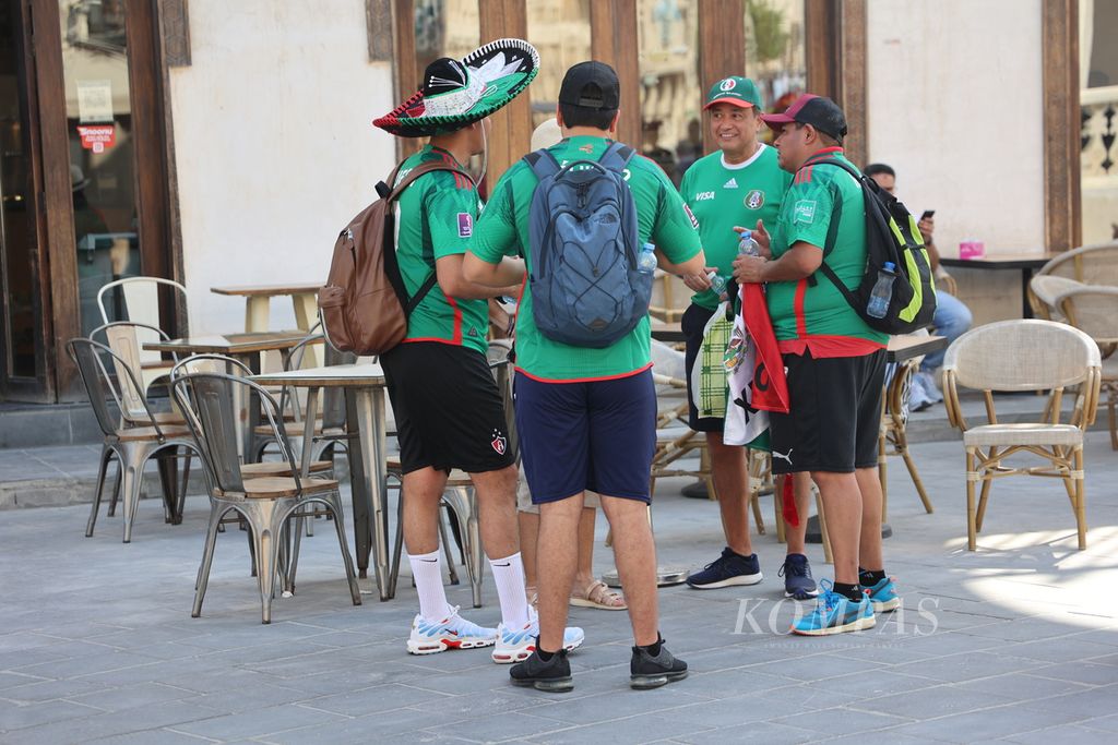 Pendukung Meksiko mengobrol di depan sebuah restoran di Souq Waqif, Doha, Qatar, Kamis (17/11/2022). Souq Waqif menjadi salah satu titik kumpul para turis asing dan pendukung sepak bola yang datang untuk menyaksikan Piala Dunia 2022. 