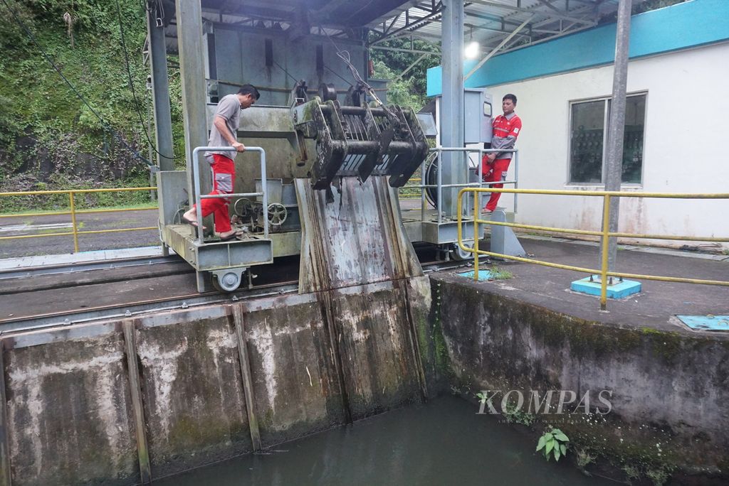Petugas mengoperasikan alat penangkap sampah di pintu bendungan intake PLTA Tanggari I di Desa Tonsea Lama, Tondano Utara, Minahasa, Sulawesi Utara, Rabu (19/1/2022).