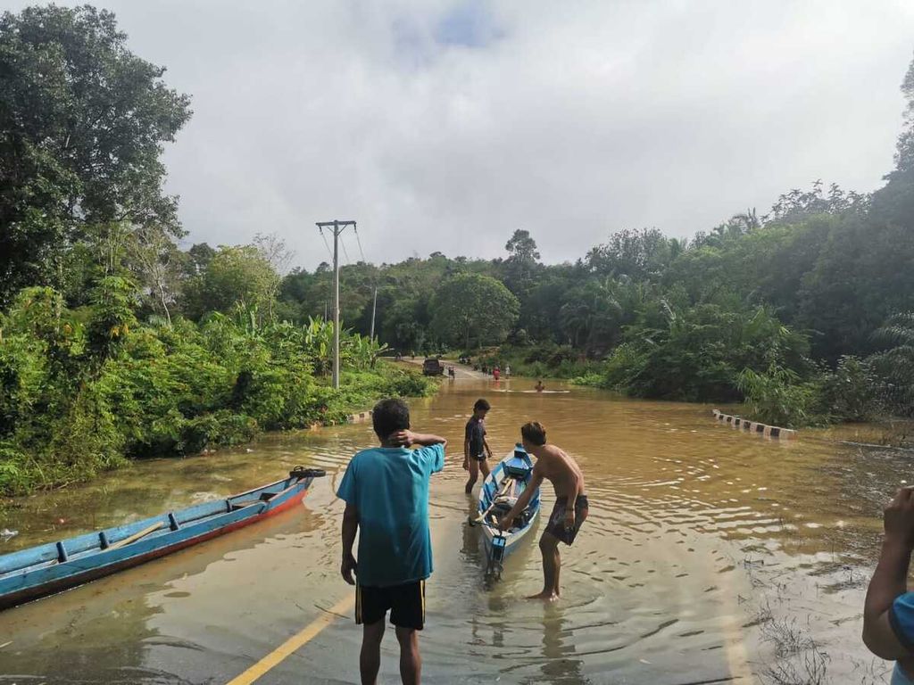 Banjir merendam jalan Trans-Kalimantan di wilayah Desa Sepoyu, Kabupaten Lamandau, Senin (10/10/2022). Banjir itu memutus jalan yang menghubungkan dua provinsi.