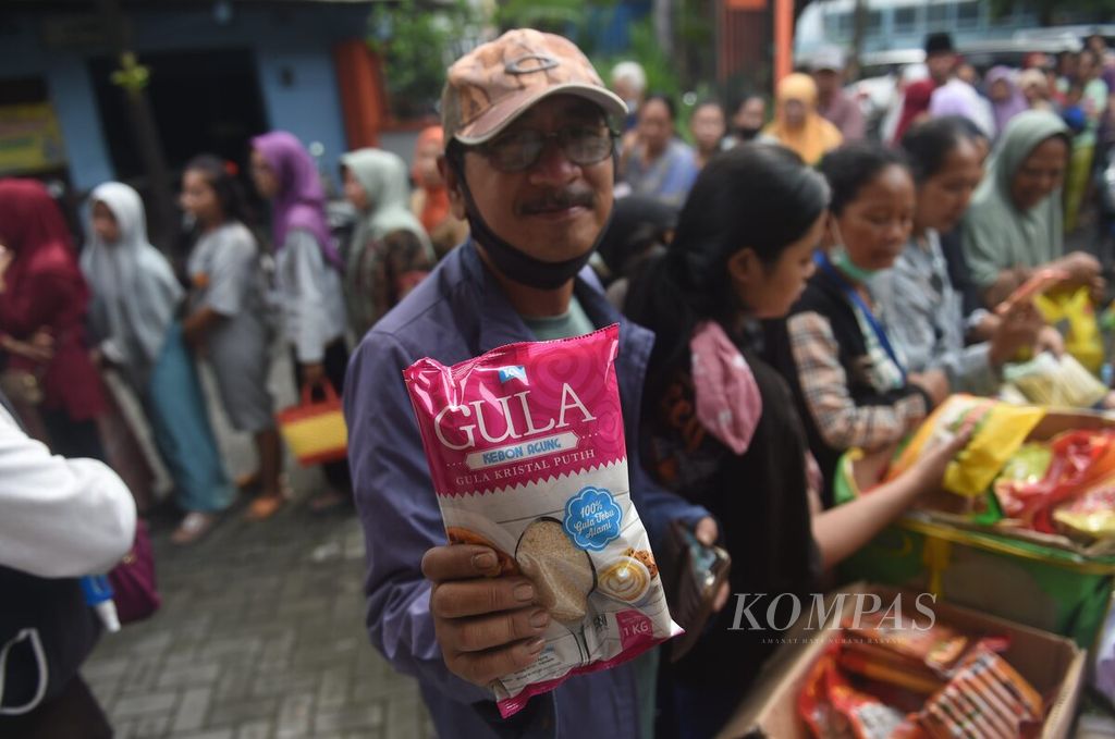Warga menunjukkan beras yang dijual saat pasar murah di Kantor Kelurahan Putat Jaya, Kecamatan Sawahan, Surabaya, Selasa (12/3/2024).