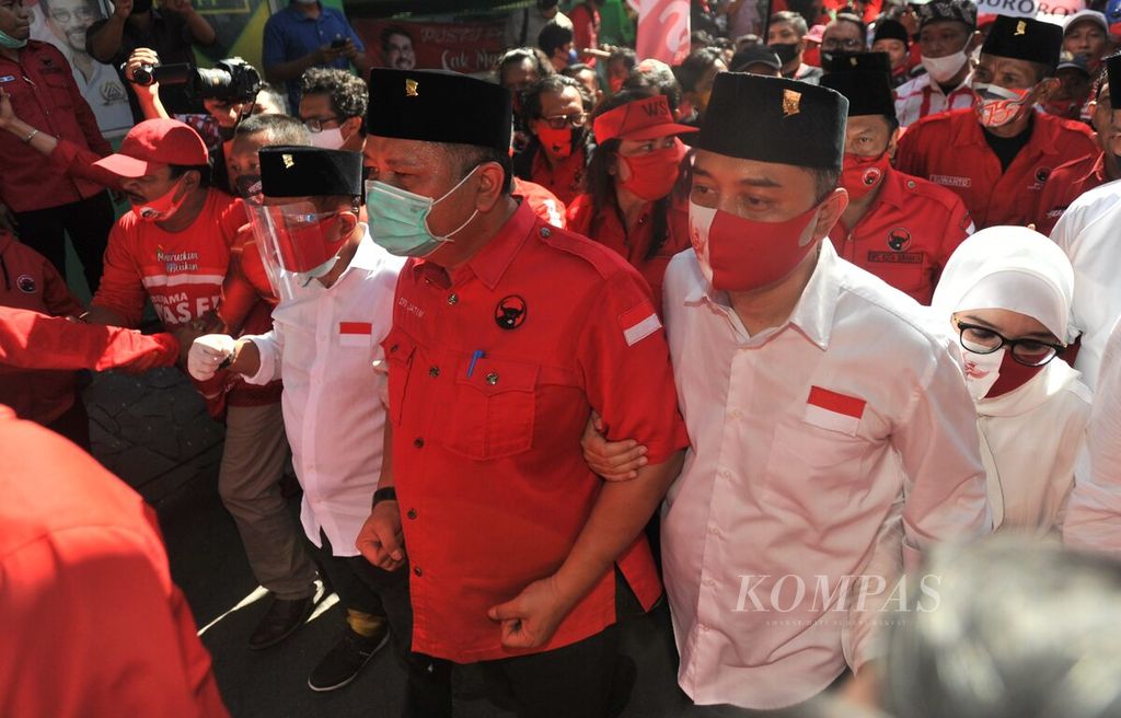 Eri Cahyadi (kanan) dan Armuji (kiri) ditemani oleh Wakil Ketua DPD PDI Perjuangan Jawa Timur Wisnu Sakti Buana (tengah) untuk mendaftarkan diri dalam pemilihan wali kota ke Kantor KPU Kota Surabaya, Surabaya, Jawa Timur, Jumat (4/9/2020).