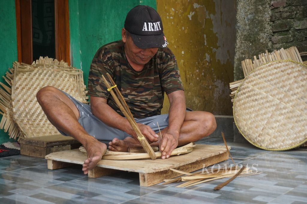 Dulmar (62), perajin bambu, menyelesaikan pembuatan tampah di Desa Mujur, Kecamatan Kroya, Kabupaten Cilacap, Jawa Tengah, Selasa (4/7/2023).