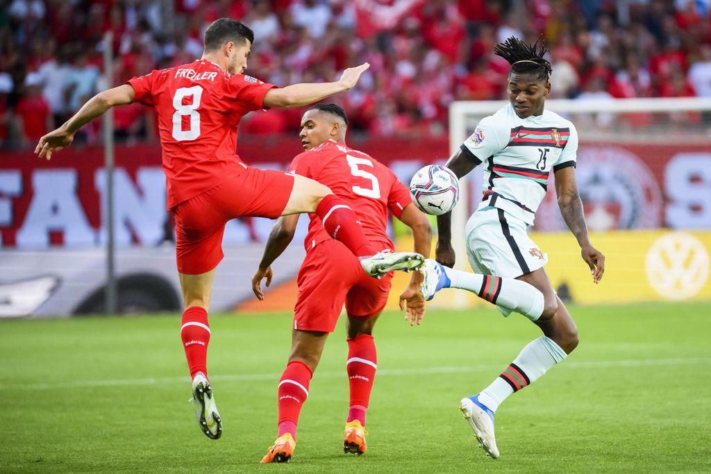 Gelandang Swiss Remo Freuler (kiri) beribaku dengan penyerang Portugal Rafael Leao dalam Liga Nasional Eropa grup A2 di Stadion Stade de Geneve, Jenewa, Swiss, Senin (13/6/2022) dini hari WIB. Portugal kalah 0-1 dari Swiss pada laga itu.
