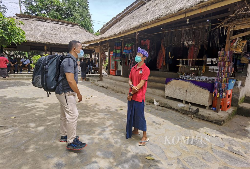 Wisatawan yang baru tiba mendengar penjelasan dari pemandu di di Dusun Adat Sasak Sade, Desa Rembitan, Kecamatan Pujut, Lombok Tengah, Nusa Tenggara Barat, Selasa (29/12/2020). Kehadiran wisatawan mengisi libur Tahun Baru 2020 diharapkan bisa menggairahkan kembali pariwisata Lombok yang terpuruk akibat pandemi Covid-19. Tetapi pada saat yang sama kedisiplinan terhadap protokol kesehatan harus jadi prioritas sehingga tidak memunculkan klaster baru penularan Covid-19 dari pariwisata.