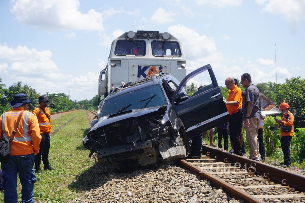 Sebuah lokomotif dikerahkan untuk menarik mobil yang terjepit di jembatan kereta api di Sumpiuh, Banyumas, Jawa Tengah, Rabu (19/4/2023).