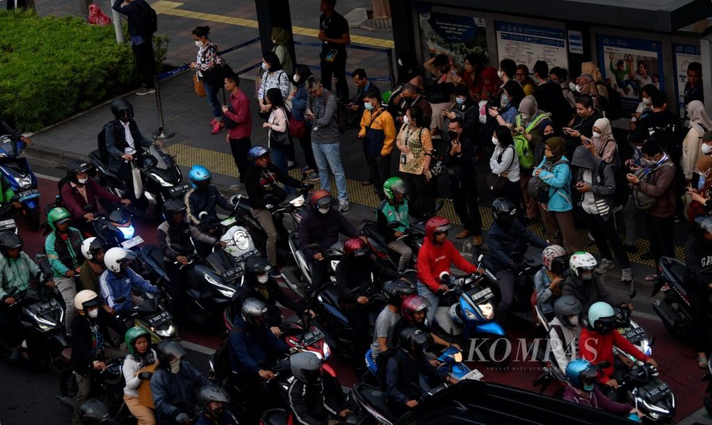 Di tengah kondisi polusi udara, sebagian besar besar pekerja mengenakan masker saat menunggu di  halte Trans Jakarta di Jalan Sudirman, Jakarta, saat jam pulang kerja, Selasa (29/8/2023).