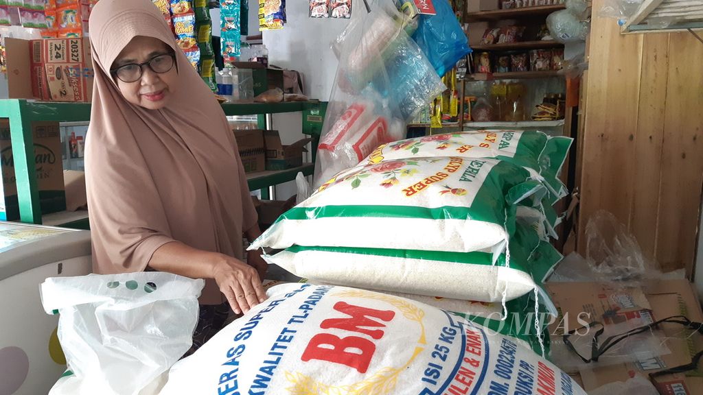 Sanimah (50), pedagang beras di Kecamatan Natar, Kabupaten Lampung Selatan, Lampung, menunjukkan stok beras yang ada di tokonya, Kamis (9/2/2023).