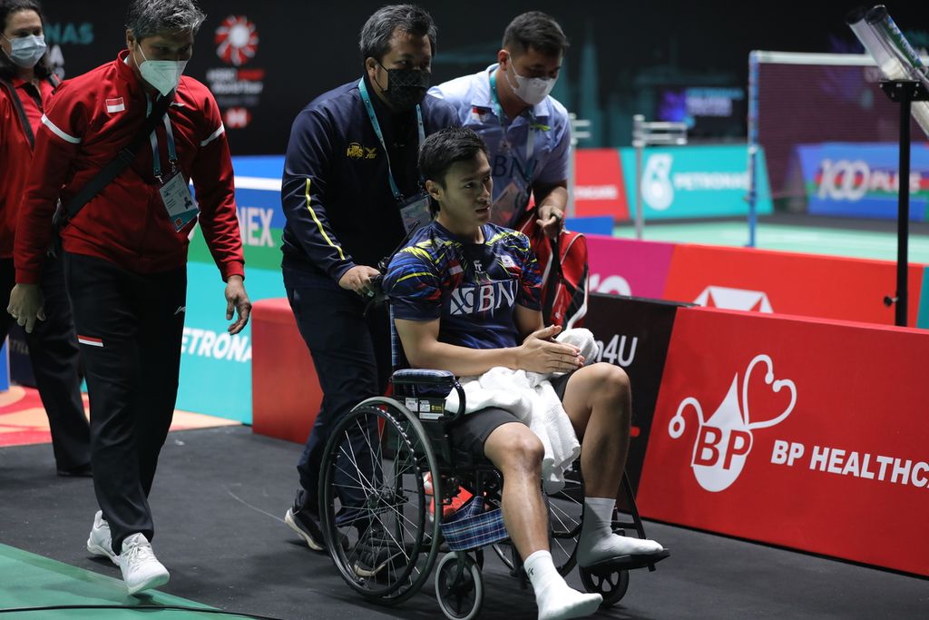 Shesar Hiren Rhustavito meninggalkan lapangan dengan kursi roda karena cedera betis kanan saat melawan Kento momota (Jepang) pada laga perempat final turnamen bulu tangkis Malaysia Terbuka di Axiata Arena, Kuala Lumpur, Jumat (1/7/2022).